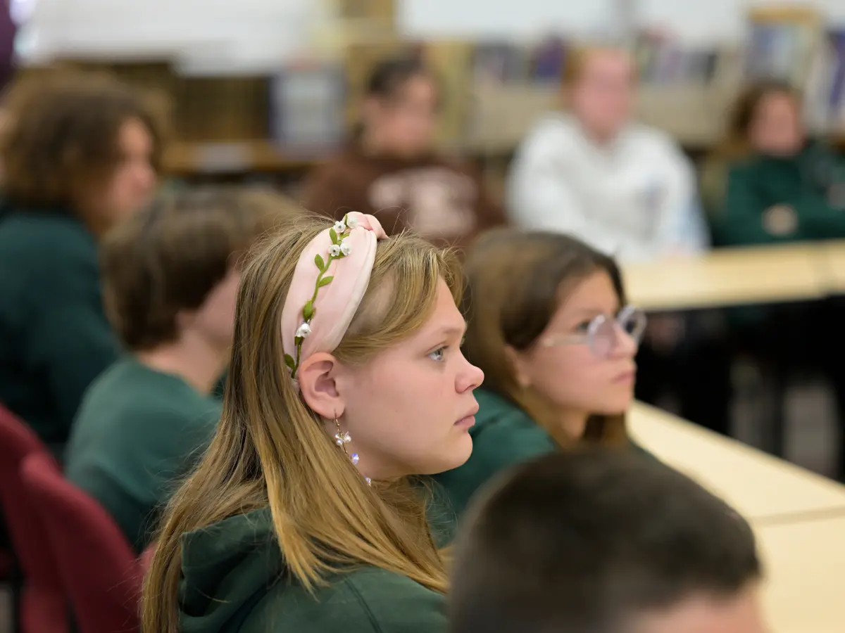 Holocaust survivor or educator speaking to students in a classroom setting