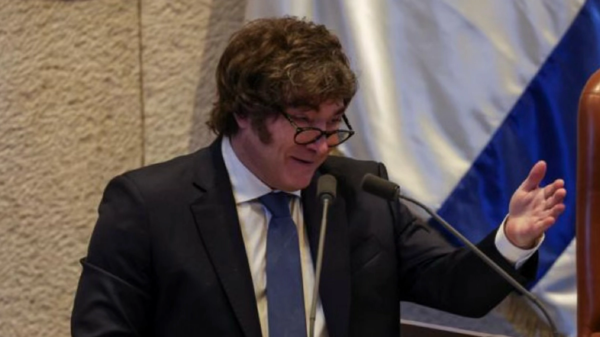 Argentine President Javier Milei speaking at a podium inside the Israeli Knesset, Israeli flag visible in background